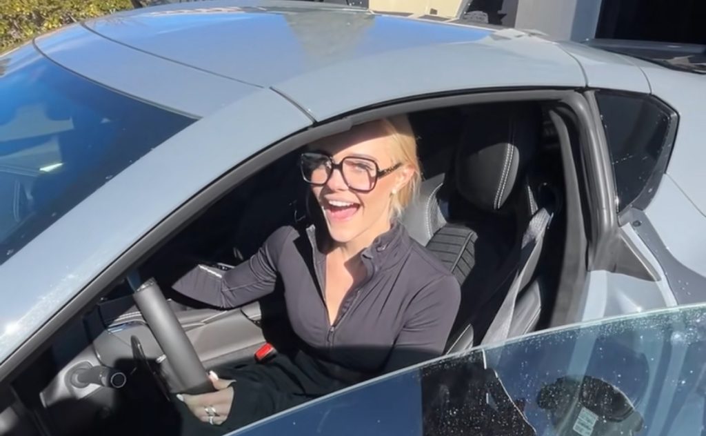 A beautiful model excited to be in a Chevy Corvette Z06.